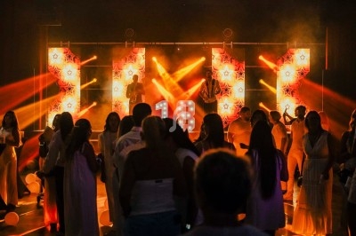 Groupe de personnes dansant dans une salle sombre éclairée par des lumières colorées et des décorations lumineuses.