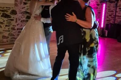 Deux couples dansent sur une piste éclairée par des lumières colorées, dans une salle aux murs en pierre.