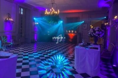 Salle de réception avec éclairage coloré, sol en damier noir et blanc, et décorations élégantes.