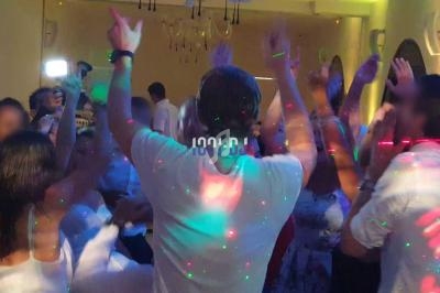 Groupe de personnes dansant dans une salle éclairée par des lumières colorées et des spots.