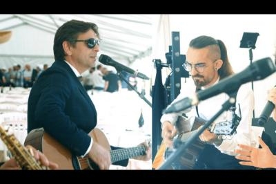 Un groupe de musiciens et une chanteuse se produisent sous une tente lors d'un événement festif.