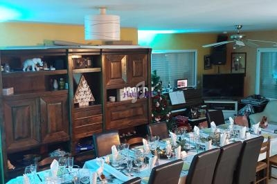 Table dressée pour un repas festif dans une salle à manger avec décoration lumineuse et mobilier en bois.