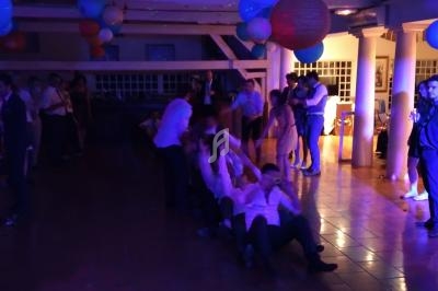 Des personnes participent à un jeu collectif dans une salle décorée, éclairée par des lumières colorées.