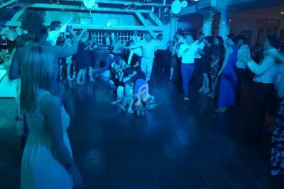 Des personnes dansent et s'amusent sur une piste éclairée de lumières bleues lors d'une fête ou d'un événement.