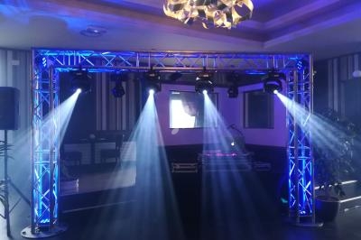 Structure métallique avec éclairages LED projetant des faisceaux lumineux bleus dans une salle sombre.