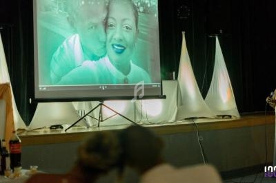 Projection d'une photo de couple sur un écran lors d'un événement dans une salle décorée avec des lumières tamisées.