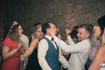Des personnes dansent et s'amusent lors d'une fête dans une salle à l'éclairage tamisé.
