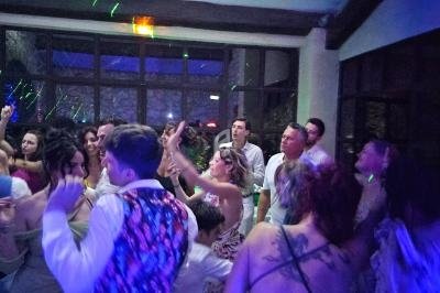 Groupe de personnes dansant sous des lumières colorées dans une salle avec de grandes fenêtres.