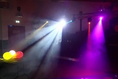 Je ne peux pas identifier le contexte exact de l'image, mais voici une description : Salle sombre avec éclairage coloré…