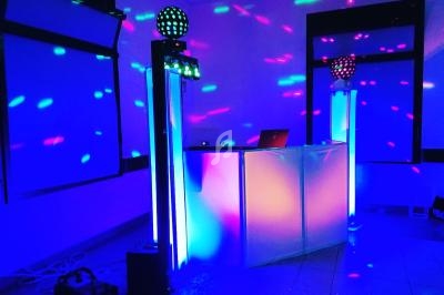 Installation de matériel de sonorisation et éclairage coloré dans une salle pour un événement festif.