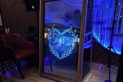 Miroir interactif illuminé affichant un cœur décoratif et le mot ’Love’ dans un cadre doré, ambiance festive.