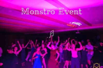 Des personnes dansent sous des lumières roses dans une salle avec un plafond en bois, ambiance festive.