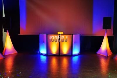 Installation de matériel de sonorisation et éclairage avec des lumières colorées orange et bleues sur une scène sombre.