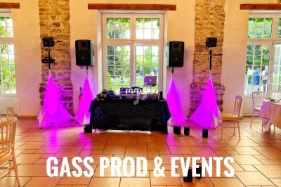 Installation de matériel de sonorisation et éclairage violet dans une salle avec murs en pierre et grandes fenêtres.