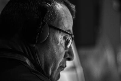 Homme portant un casque audio, vu de profil, concentré dans un environnement sombre en noir et blanc.