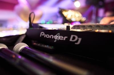 Table de mixage Pioneer DJ en gros plan avec deux microphones à l'avant, dans un environnement lumineux.