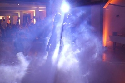 Deux personnes dansant dans une ambiance tamisée avec des effets de lumière et de fumée.