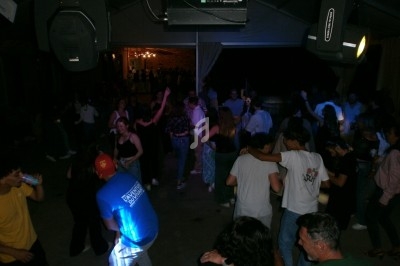 Groupe de personnes dansant et discutant lors d'une soirée en intérieur, éclairée par des lumières tamisées.