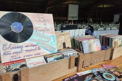 Bacs en bois contenant des vinyles variés avec un panneau indiquant ’Bar à Vinyles’ dans un espace intérieur.