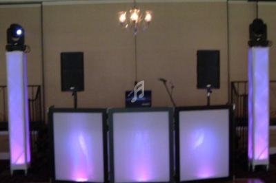 Installation de matériel de sonorisation et d'éclairage avec haut-parleurs, micros et lumières colorées dans une salle.