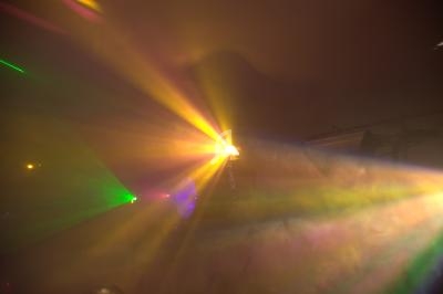 Effets lumineux colorés diffusés par des projecteurs dans une ambiance enfumée.
