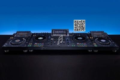 Console DJ professionnelle avec platines, table de mixage et écran central, posée sur une surface noire.