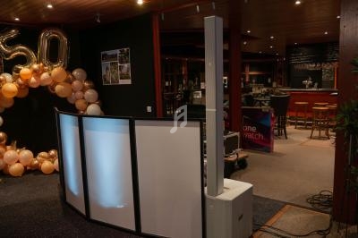 Décoration d'anniversaire avec ballons formant le chiffre 50, dans une salle avec bar et éclairage tamisé.