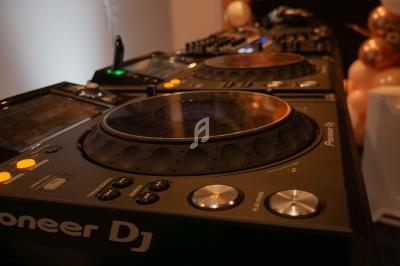 Table de mixage DJ avec platines Pioneer entourée de ballons décoratifs dans un environnement festif.