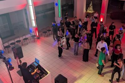 Vue d'une soirée dansante avec un DJ en action, des invités sur la piste et une ambiance lumineuse colorée.