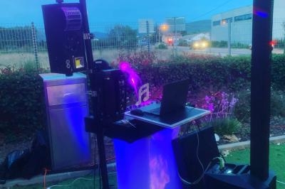 Installation de matériel de sonorisation et d'éclairage en extérieur, avec table de mixage et haut-parleurs.