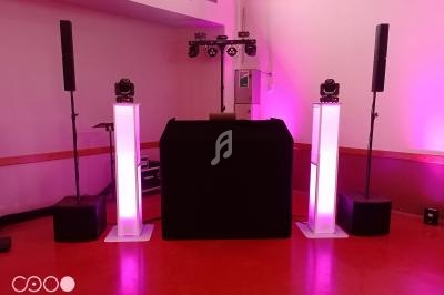 Installation de matériel de sonorisation et d'éclairage avec des colonnes lumineuses dans une salle intérieure.