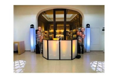 Comptoir lumineux décoré de ballons dans une salle moderne avec éclairage tamisé et sol en carrelage clair.