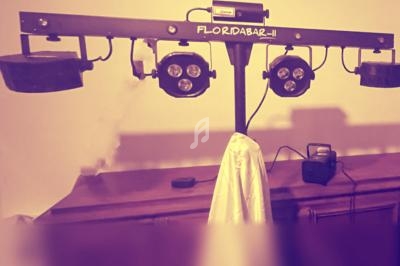 Support lumineux avec projecteurs LED suspendus, posé sur un meuble en bois, avec un tissu blanc accroché.