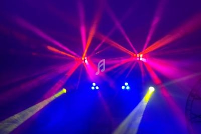 Effets lumineux colorés avec faisceaux rouges, jaunes et bleus dans une ambiance sombre.