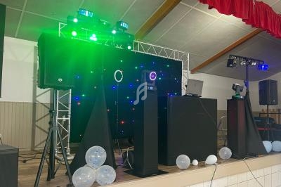 Équipement de sonorisation et éclairage installé sur une scène avec des ballons au sol.