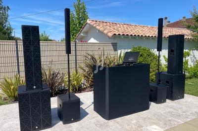 Ensemble de matériel de sonorisation installé en extérieur, comprenant enceintes, caissons de basses et table de mixage.