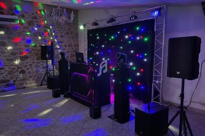 Installation de matériel de sonorisation et éclairage coloré dans une salle avec murs en pierre.