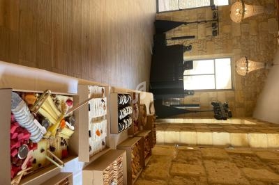 Buffet de desserts variés disposés sur une table en bois dans une salle en pierre avec des lustres suspendus.