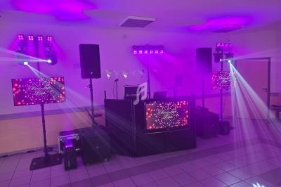 Installation de matériel de sonorisation et d'éclairage avec écrans et projecteurs dans une salle.