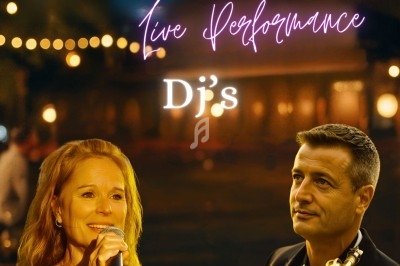 Deux personnes chantent et jouent de la musique en direct dans une ambiance nocturne éclairée par des lumières.