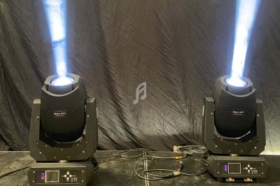 Deux projecteurs de scène émettant des faisceaux lumineux blancs sur un fond noir.