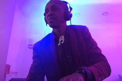 Homme portant un casque audio, concentré, dans une ambiance lumineuse violette et bleue.