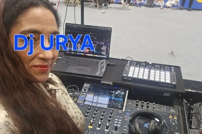 Femme devant une table de mixage avec un ordinateur, des casques et des équipements audio, dans une salle sportive animée.