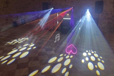 Jeux de lumières colorées projetés sur un sol carrelé dans une salle sombre, avec un motif en forme de cœur.