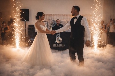 Un couple danse au milieu d'une piste enveloppée de fumée, entouré d'étincelles et d'invités en arrière-plan.