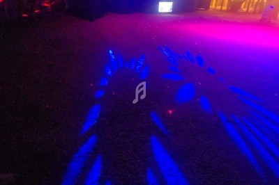 Jeux de lumières bleues et roses projetés sur un sol sombre dans un espace intérieur.